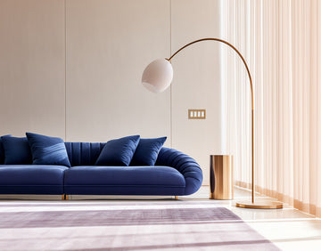 kul plates 4g anodized matte gold switch in minimalist space with bold blue sofa and gold accents 1